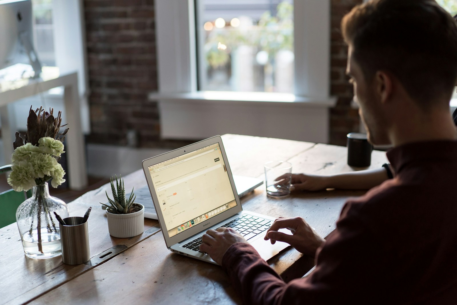 man operating laptop on top of table bussiness