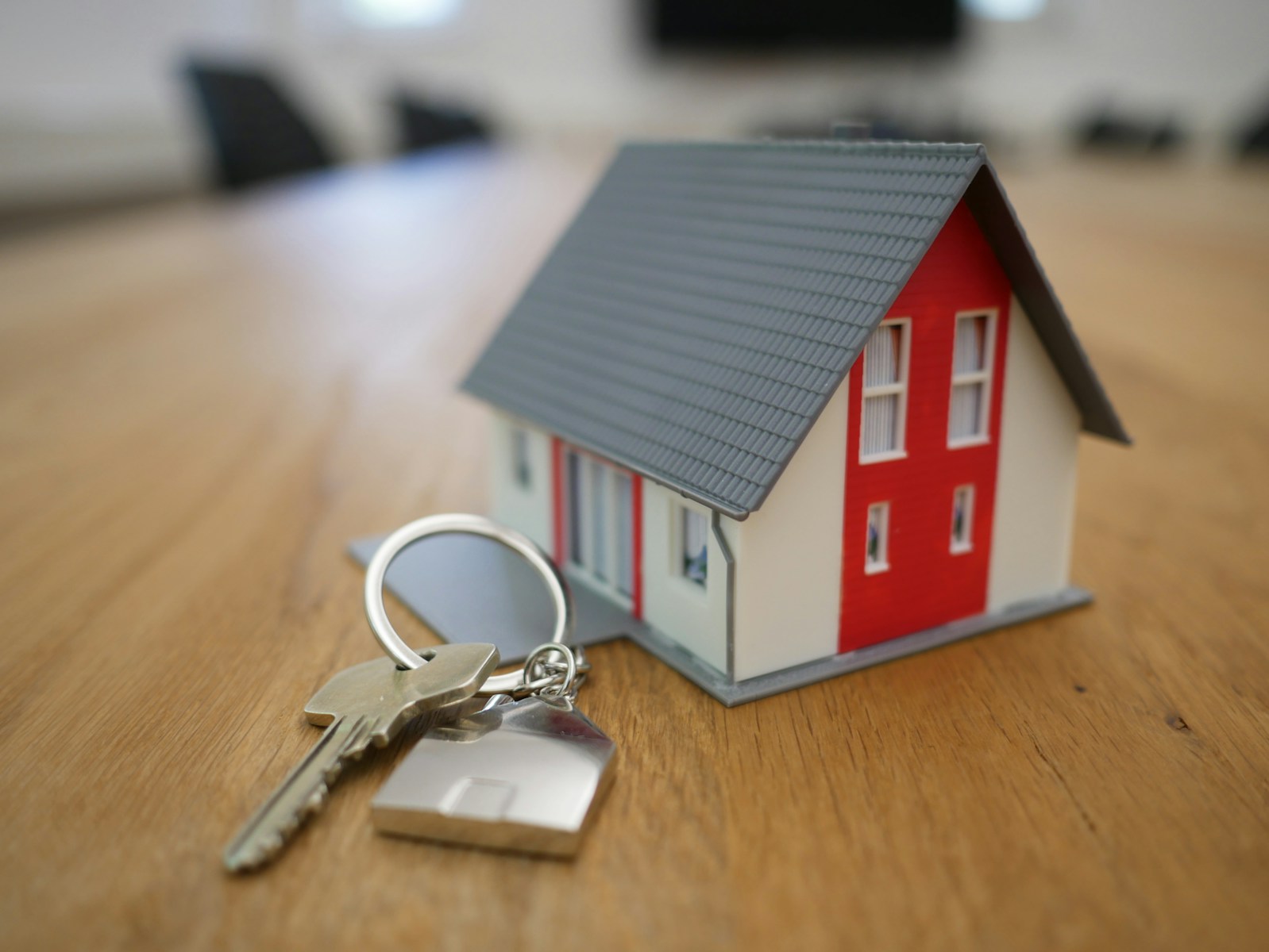 white and red wooden house miniature on brown table, personal umbrella